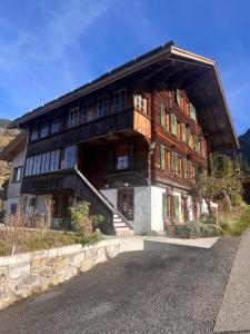 un grande edificio in legno con una bisca di Blüemlisalp-Huus im Kiental a Kiental