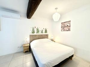 una camera da letto con un letto con alberi di Natale sul muro di Studio Sencha, Lit 160, Clim, plein coeur de ville a Nîmes Altre 3 foto