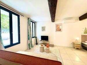 un soggiorno con un divano e una TV di Studio Sencha, Lit 160, Clim, plein coeur de ville a Nîmes