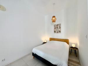a white bedroom with a bed and two side tables at Studio Boho, 4 personnes Nîmes, Lit 160 + CLIM in Nîmes +4 photos
