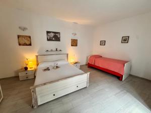 a bedroom with two beds and a red bedvisor at Stanza Globo in Nulvi