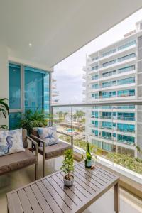 a living room with a table and a large window at Escapada 5 estrellas frente al mar - sonest morros in Cartagena de Indias