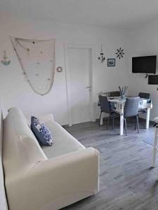 een woonkamer met een witte bank en een tafel bij Antema in Scario