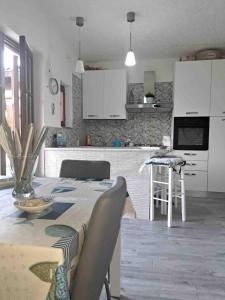 een keuken met een tafel en een keuken met witte kasten bij Antema in Scario