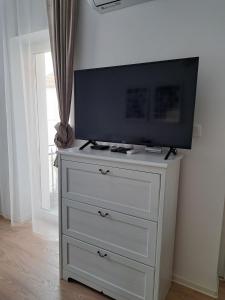 a white dresser with a television on top of it at CozyCentralApartment in Kecskemét