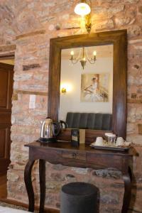 a mirror on a stone wall with a wooden table at Archontiko in Andritsaina