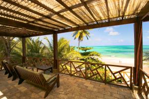 a porch with chairs and a view of the beach at Aruanã Pousada in Jacumã