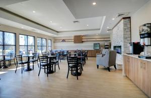 a dining room with tables and chairs in a restaurant at Anchorage Inn & Suites - Portsmouth in Portsmouth