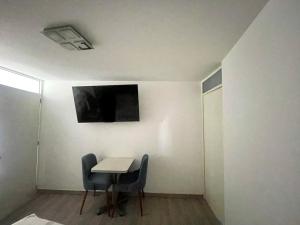 a room with a table and two chairs and a tv at Casa de Bris in Arequipa