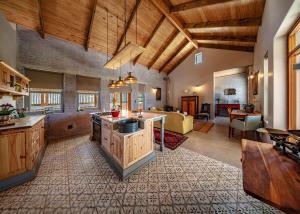 a large kitchen with wooden ceilings and a living room at fijnbosch manor at romansbaai in Gansbaai