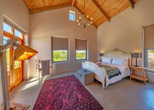 a bedroom with a bed and a red rug at fijnbosch manor at romansbaai in Gansbaai