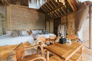 a room with two beds and a table and chairs at เลอดอย Le Doi in Ban Huai Khai