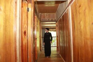a woman walking down a hallway in a building at Ba Be Retreat in Bak Kan