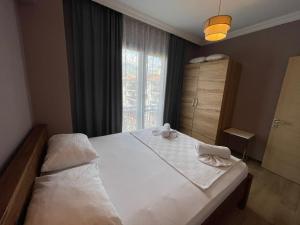 a bedroom with a large white bed with a window at Narac Dom in Fethiye