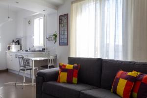 Una sala de estar con un sofá y una cocina. en Cuore Flat, en Módica