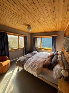 a bedroom with a large bed with a wooden ceiling at Familiehotel La Randulina in Ramosch