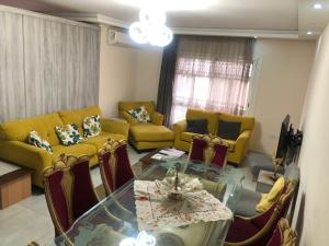 a living room with a glass table and yellow chairs at القاهره in Madinaty