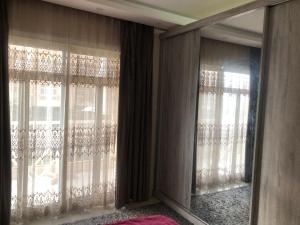a room with two windows with curtains and a mirror at القاهره in Madinaty
