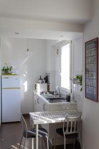 a white kitchen with a sink and a stove at Cuore Flat in Modica