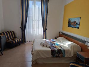 a hotel room with a bed and a chair at Eden Hotel in Deiva Marina