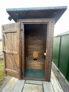 a wooden outhouse with a toilet inside of it at Maringotka u potůčku in Černovice +8 photos