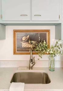 un lavandino in una cucina con un dipinto sopra di Cottage on King Charming Historic Leesburg Home a Leesburg