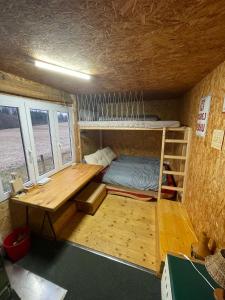 a room with a bed and a desk in a tiny house at Maringotka u potůčku in Černovice