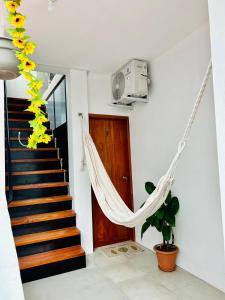 a hanging hammock in a room with a staircase at Suite Economy in Puerto Ayora