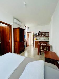 Un dormitorio con una cama y una mesa y una cocina. en Suite Economy Double, en Puerto Ayora