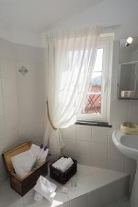 a white bathroom with a sink and a window at Relais Borgofasceo in Ortovero