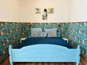 a bedroom with a blue bed with a floral wallpaper at Ferienwohnung an der Therme in Bad Rodach