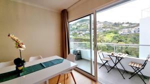 a dining room with a table and a large window at Pestana Green View in Caniço