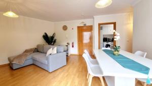 a living room with a white table and a couch at Pestana Green View in Caniço