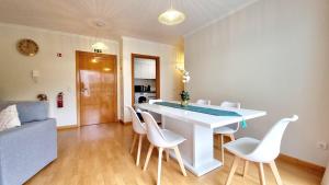 a living room with a white table and white chairs at Pestana Green View in Caniço +12 photos