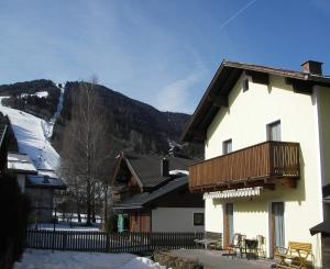 a building with a balcony and a snow covered mountain at Almliesl ZELL-374 in Zell am See