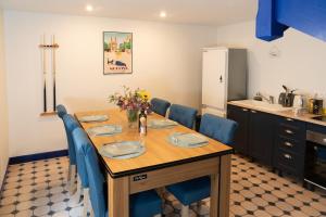 a dining room table with blue chairs and a kitchen at Appartement campagne in Moulins