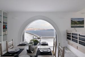 een eetkamer met een tafel en uitzicht op de oceaan bij Beautiful Oia Villa in Oia