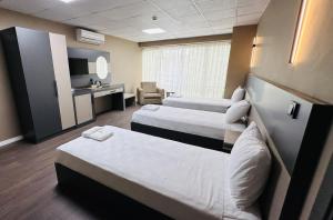 a hotel room with two beds and a tv at Esse Joven Hotel in Antalya