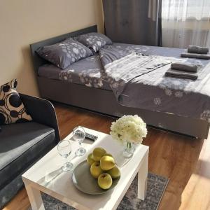 a living room with a bed and a table with a plate of fruit at LUX apartament in Warsaw