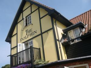 a yellow and black building with a sign on it at The Dolphin Inn in Thorpeness