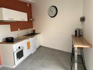 a kitchen with a clock on the wall and a counter at Autour de la bulle in Prunay