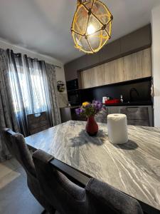 a dining room table with a vase of flowers on it at Apartman Nonno Božo 2 in Fažana
