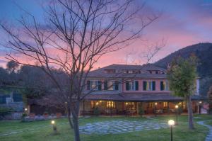 a large house with a tree in the yard at Relais Borgofasceo in Ortovero