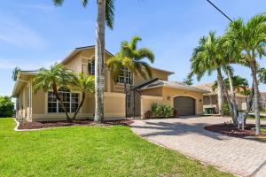 ein Haus mit Palmen davor in der Unterkunft Villa Estelle - Huge lake front Villa in Cape Coral