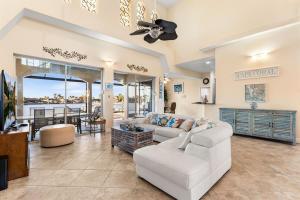 ein Wohnzimmer mit einem weißen Sofa und einem Deckenventilator in der Unterkunft Villa Estelle - Huge lake front Villa in Cape Coral
