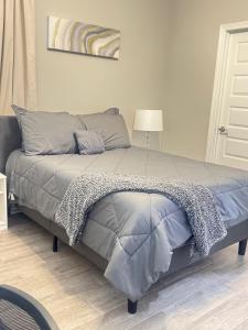 a bed with a gray comforter in a bedroom at Premier Luxe Villa in Weslaco