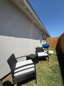 a patio with two chairs and a blue frisbee at Premier Luxe Villa in Weslaco