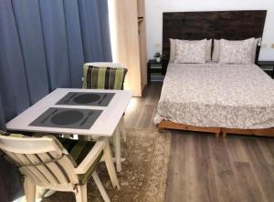 Un dormitorio con una cama y una mesa y sillas. en Las Americas Holiday Studio, en Adeje 4 fotos más