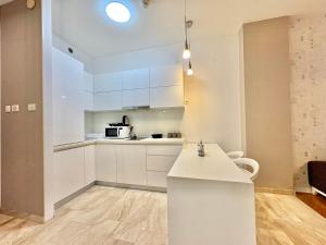 a kitchen with white cabinets and a counter top at The Royal Suite - Tre Canne in Budva