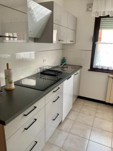 a kitchen with white cabinets and a black counter top at APARTMA PANORAMA in Kobarid